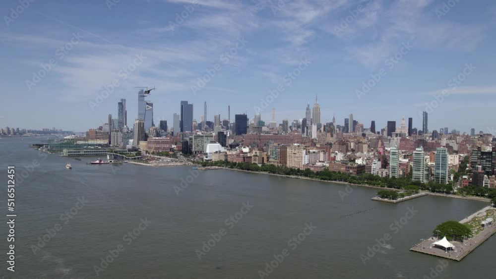 Aerial view of a helicopter flying over the Hudson river in front of the Midtown Manhattan cityscape, sunny, summer day in NYC, USA Aerial view of a helicopter flying over the Hudson river in front of the Midtown Manhattan cityscape, sunny, summer day in NYC, USA