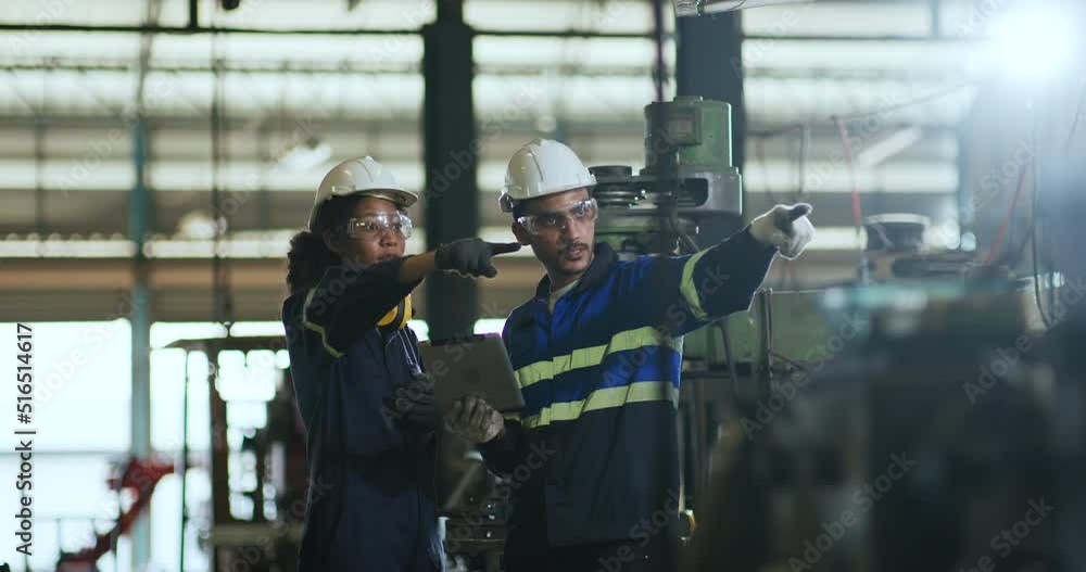 Industrial Engineers in Hard Hats Discussing while working together Industrial Engineers in Hard Hats Discussing while working together