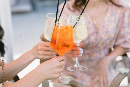 Friends having lemonade drinks on outdoors terrace. Summer lifestyle.