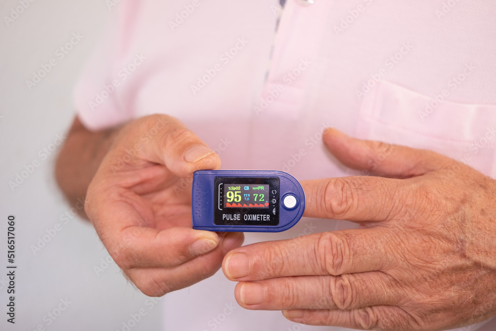 Senior Caucasian man measuring Oxygen Saturation Level Using Pulse Oximeter - coronavirus covid-19 prevention Senior Caucasian man measuring Oxygen Saturation Level Using Pulse Oximeter - coronavirus covid-19 prevention