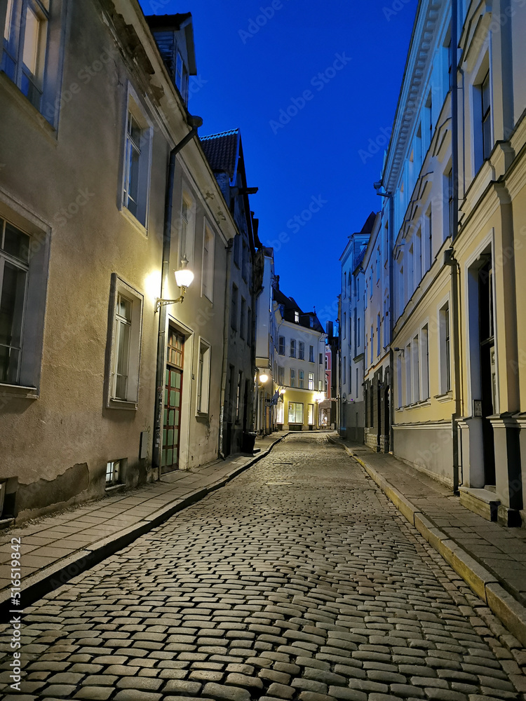 One of the narrow, cobbled streets of Old Tallinn against the blue sky. Spring evening.