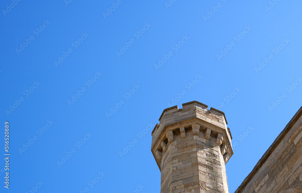Stone castle tower against a clear blue sky