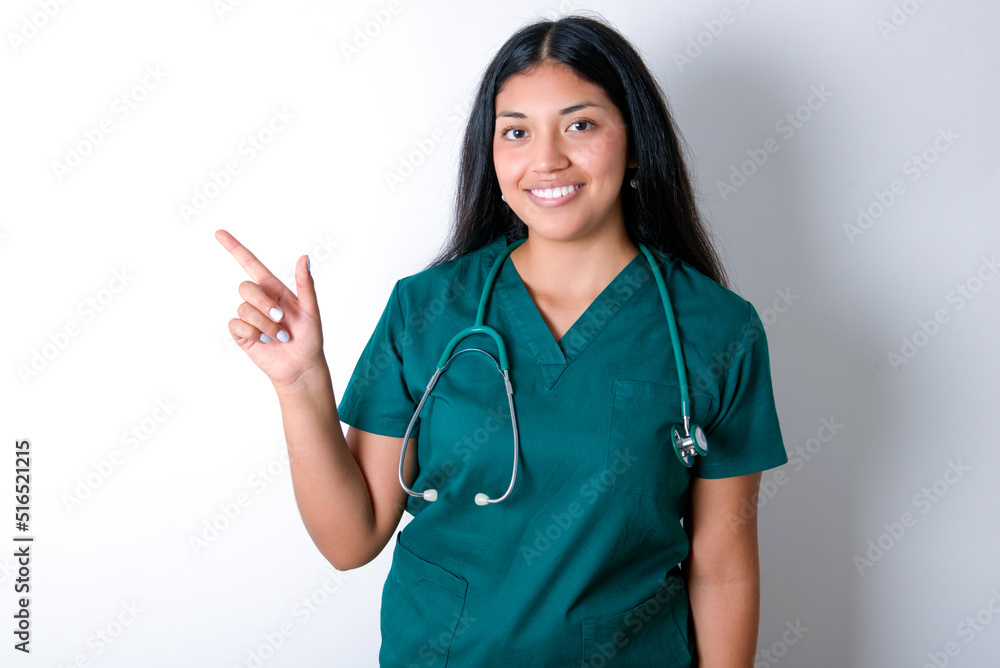 Doctor hispanic woman wearing surgeon uniform over white wall pointing up with fingers number eight in Chinese sign language BÄ.