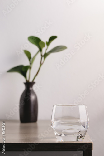 Transparent glass with water on a wooden table in the room. Drinking clear water in the morning for health..