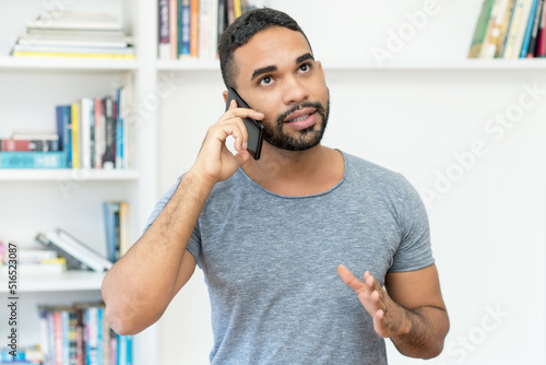 Hispanic hipster man with beard talking at mobile phone