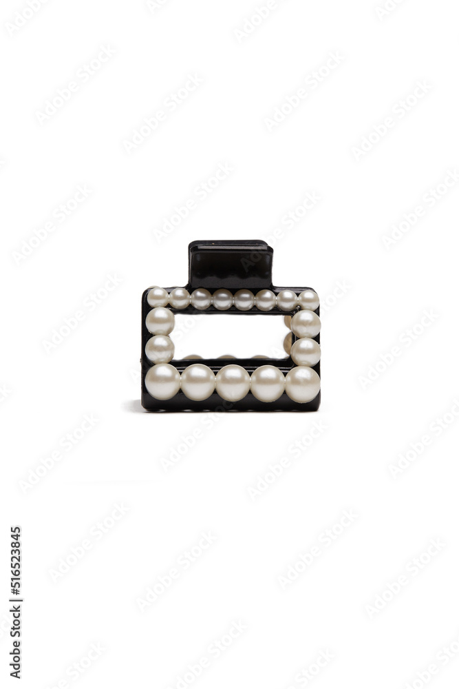 Subject shot of a black hair clip decorated with pearls. The hair clip is isolated on the white background. Vogue accessory for ladies and girls. Subject shot of a black hair clip decorated with pearls. The hair clip is isolated on the white background. Vogue accessory for ladies and girls.
