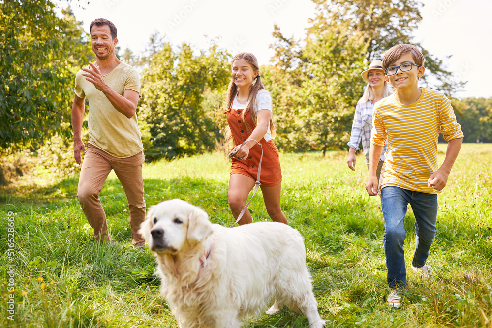 Happy family with children and dog running on meadow Happy family with children and dog running on meadow