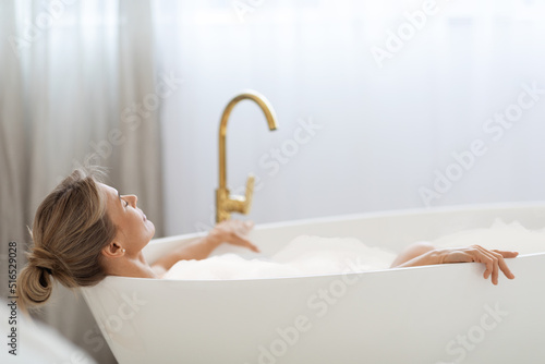 Quadro su tela Relaxed lady enjoying foamy aromatic bath at home