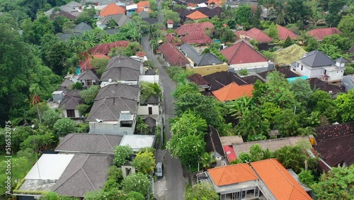 motorbike driving in local neighborhood in Umalas Bali on cloudy day, aerial photo