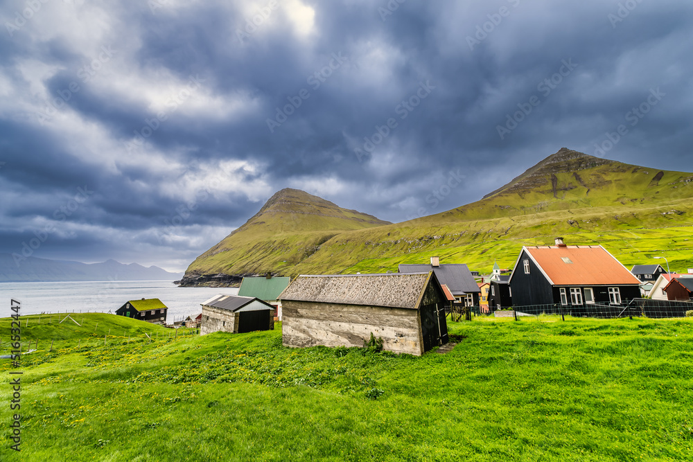 Colorful houses of Gjogv village and a small river flows into fjord. Faroe Islands, Denmark Colorful houses of Gjogv village and a small river flows into fjord. Faroe Islands, Denmark
