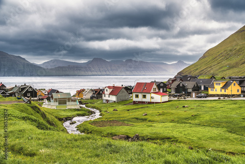 Colorful houses of Gjogv village and a small river flows into fjord. Faroe Islands, Denmark