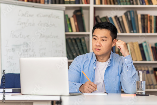 Korean Male Teacher Using Laptop Taking Notes Learning Online Indoor