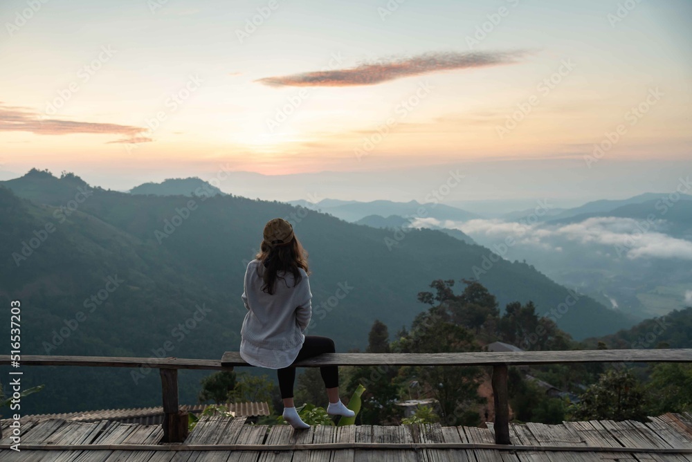 Female traveler sightseeing sea mist and mountain in vacation among sunrise at Chiang Mai, Thailand, show grain and noise Female traveler sightseeing sea mist and mountain in vacation among sunrise at Chiang Mai, Thailand, show grain and noise