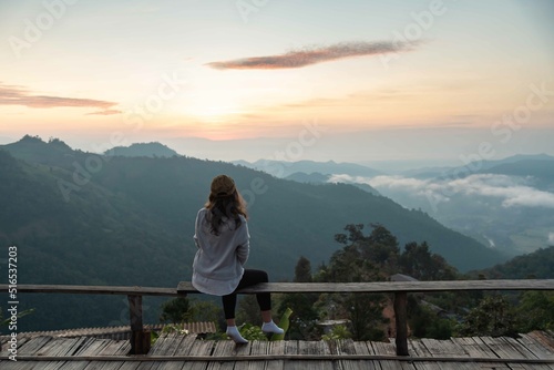 Female traveler sightseeing sea mist and mountain in vacation among sunrise at Chiang Mai, Thailand, show grain and noise