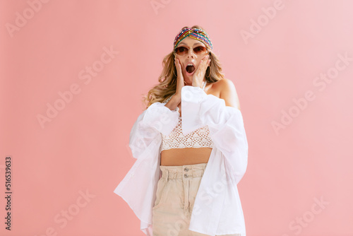 Portrait of beautiful young woman posing isolated over pink studio background. Emotive. Shocked expression