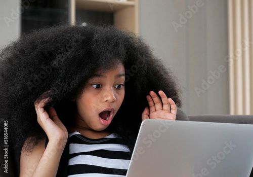 Portrait of student girl shocked and surprised using her laptop computer.