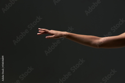 Dancer arm. Tender hands of the young delicate gentle professional baller dancer on the isolated dark grey background. Stuio. Ballerina