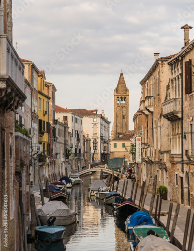 View of a canal with boats docked and traditional buildings in Venice, Italy