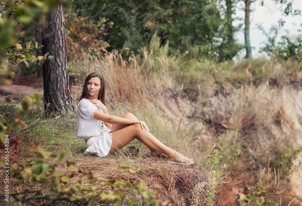 A girl on a summer day walks alone near a cliff on the seashore.
She is in white clothes A girl on a summer day walks alone near a cliff on the seashore.
She is in white clothes