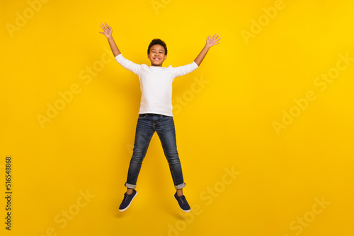 Photo of charming attractive schoolkid dressed white shirt jumping high isolated yellow color background
