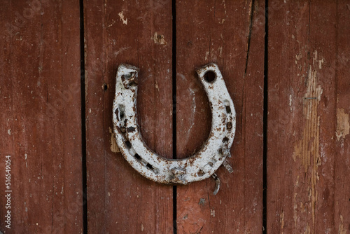 An old horseshoe hangs on old wooden doors.The concept of tradition of different peoples.