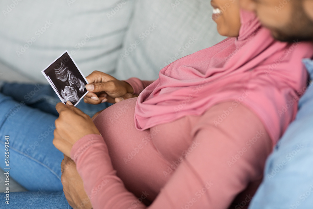 Preparing For Parenthood. Happy Black Pregnant Muslim Couple Looking At Baby Sonography Preparing For Parenthood. Happy Black Pregnant Muslim Couple Looking At Baby Sonography