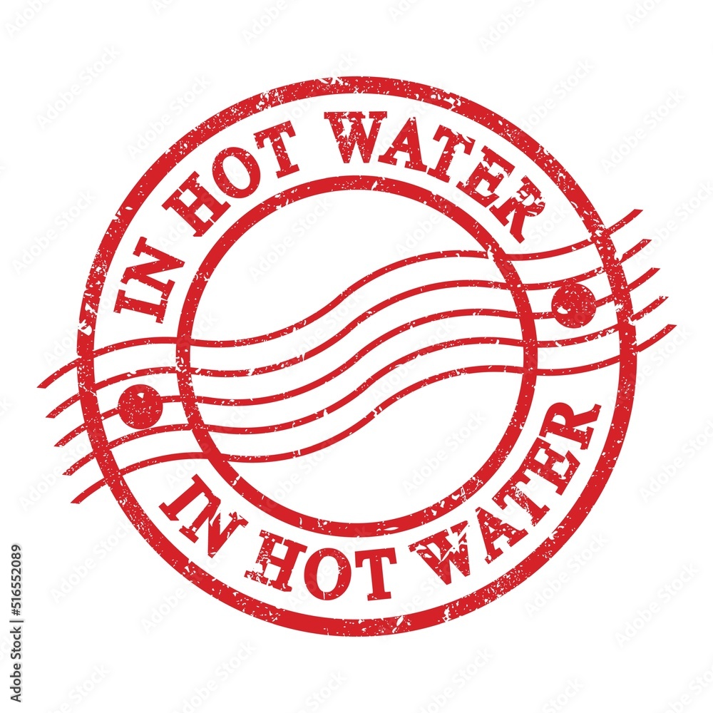 IN HOT WATER, text written on red postal stamp. IN HOT WATER, text written on red postal stamp.