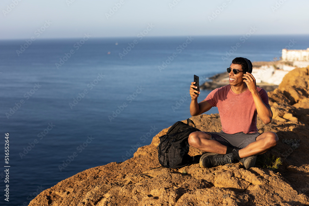 Young man taking selfie photo on a road trip. Man making memories on the mountain