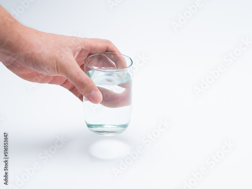 Hand holding a glass of water. Drinking 8 glasses of water per day is healthy.