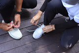 Couple of joggers tying sneakers shoelaces outdoors. Fitness, sport and lifestyle concept.
