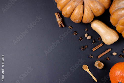Composition of pumpkins with autumn spices on black background