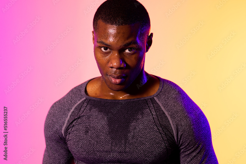 Portrait of african american male runner with sportswear over pink lighting Portrait of african american male runner with sportswear over pink lighting