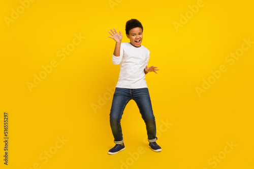 Photo of charming funky schoolboy wear white shirt smiling dancing isolated yellow color background