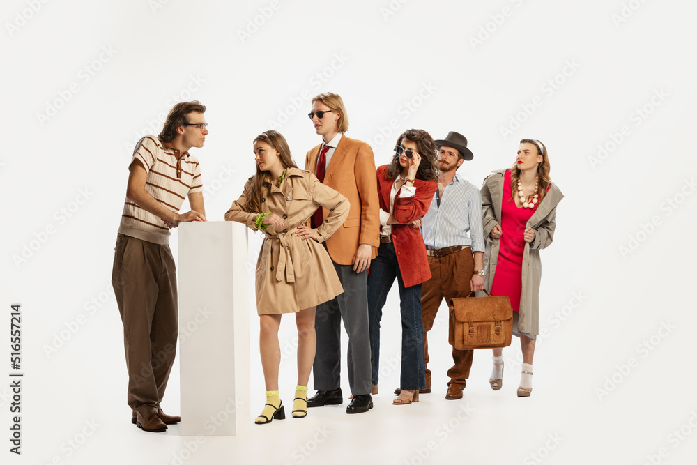 Fototapeta premium Portrait of stylish young people standing in a line, communicating isolated over white studio background