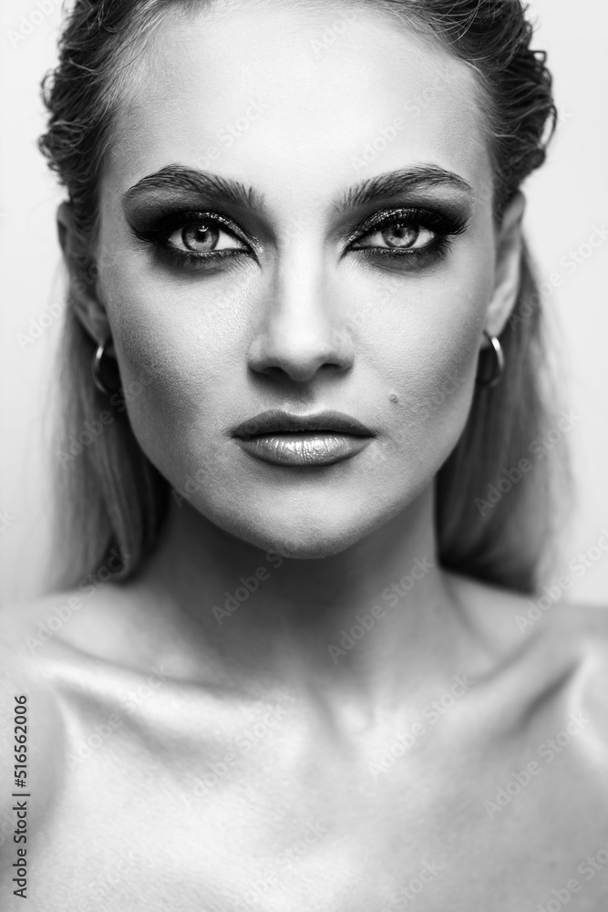 Beauty, fashion, style and makeup concept. Close up beautiful girl studio portrait. Sexy looking woman with fancy evening makeup looking to camera. Eyes is in camera focus. Black and white image Beauty, fashion, style and makeup concept. Close up beautiful girl studio portrait. Sexy looking woman with fancy evening makeup looking to camera. Eyes is in camera focus. Black and white image