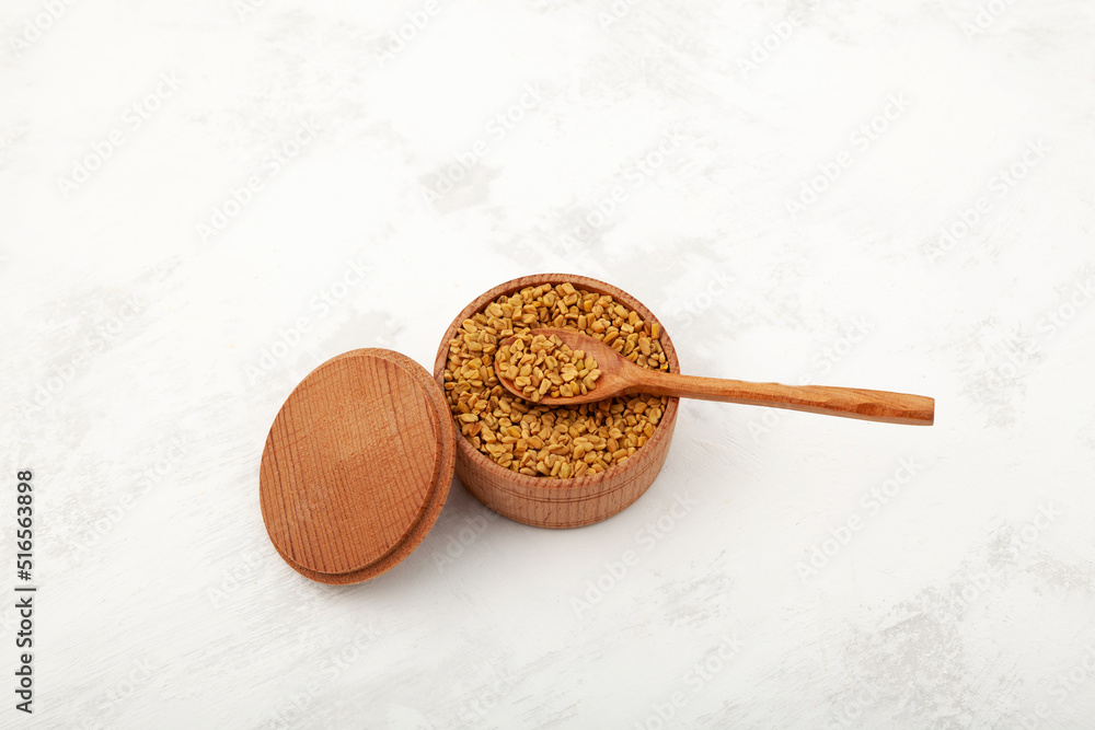 Fenugreek seeds in wooden bowl. Healthy eating. Seeds of plant Trigonella foenum-graecum used in culinary and medicine Fenugreek seeds in wooden bowl. Healthy eating. Seeds of plant Trigonella foenum-graecum used in culinary and medicine