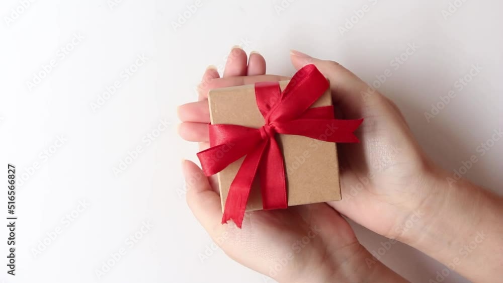 woman hands holding a small gift box on white background. woman hands holding a small gift box on white background.