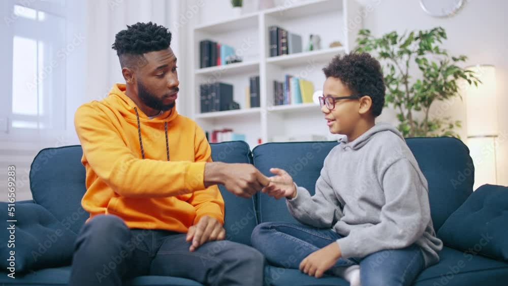 Young man giving money to his younger brother, brotherly love, siblings Young man giving money to his younger brother, brotherly love, siblings