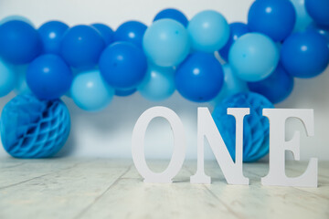 sliver, blue and white decoration for a 1st birthday cake smash studio photo shoot with balloons, paper decor, cake and topper. High quality photo
