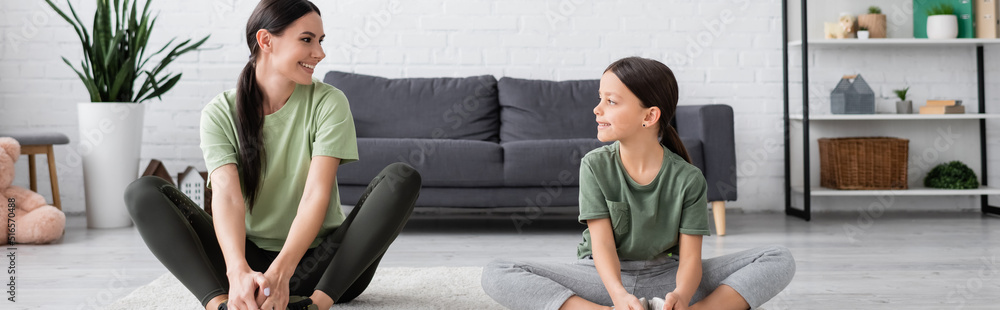 babysitter and girl sitting in fire log pose and smiling at each other, banner. babysitter and girl sitting in fire log pose and smiling at each other, banner.