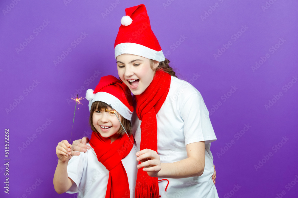 Obraz premium Winsome Two Embracing Positive Exclaiming Caucasian Girlfriends in Seasonal Warm Clothing Having Fun With Vivid Bright Burning Bengal Lights On Purple