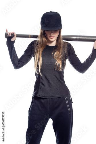 Shy Winsome Sportive Caucasian Female Baseball Player Athlete Posing With Ball and Bat Wearing Sport Outfit With Cap Against Pure White Background.