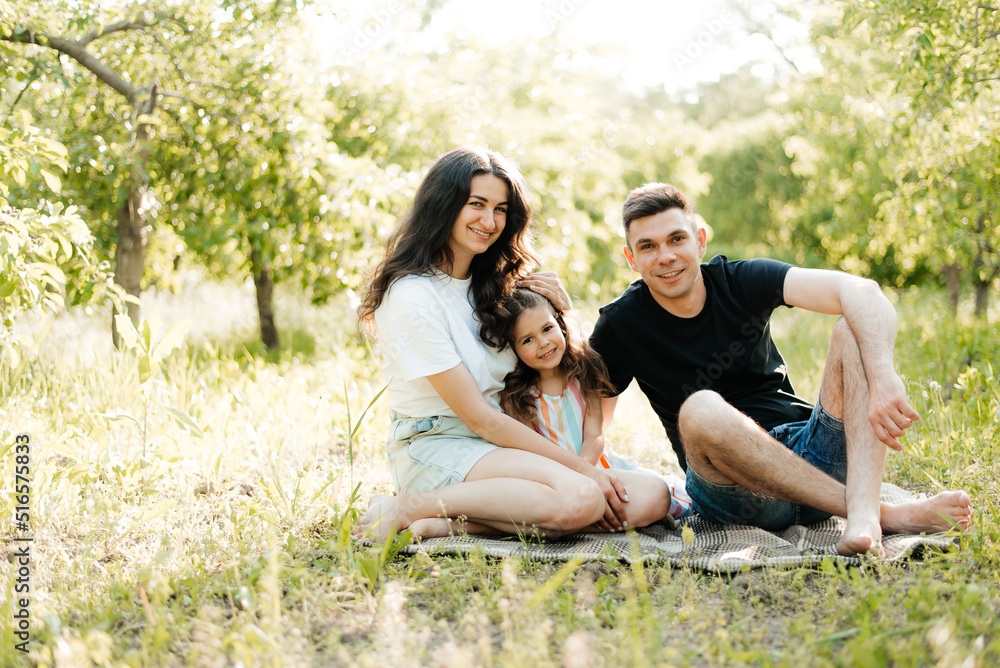 Family resting sitting on a blanket outdoors Family resting sitting on a blanket outdoors