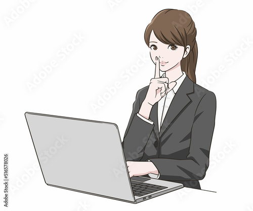 PC前で人差し指を口に当てるスーツの女性