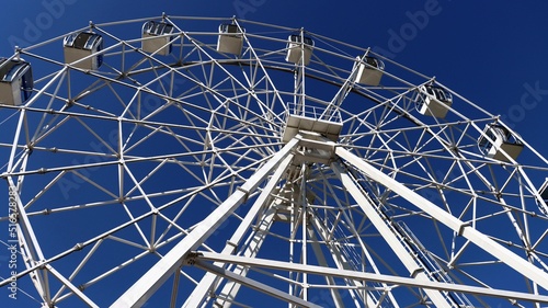 White Ferris wheel on a blue sky background