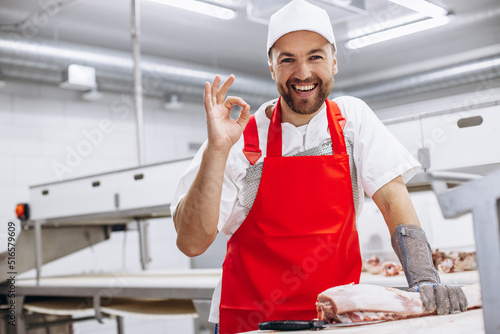 Butcher at freezer with meat showing thums up photo
