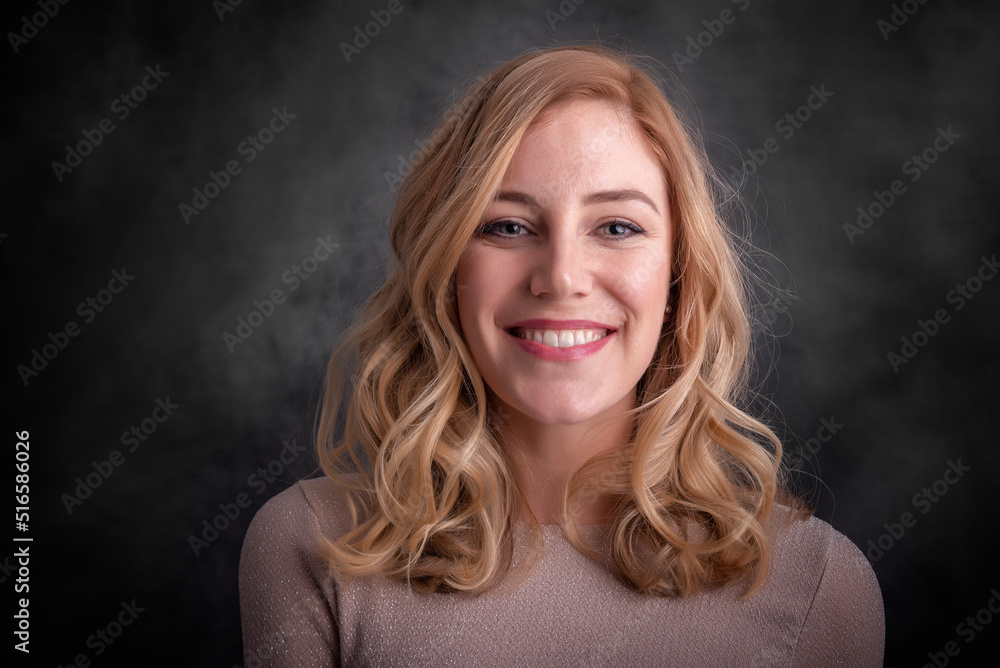 Beautiful smiling blonde on a dark background.