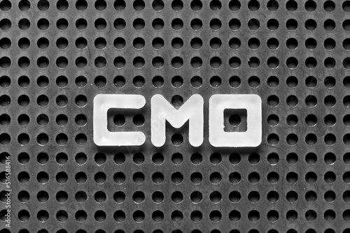 White alphabet letter in word CMO (Abbreviation of Chief Marketing Officer, Contract Manufacturing Organization) on black pegboard background photo