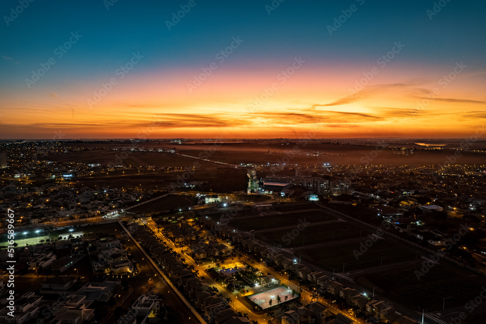 Vista aérea da cidade de Paulínia durante a noite. Pôr do sol no interior de São Paulo. Céu vermelho.