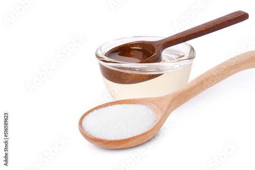 Konstfotografi Sugar syrup in glass bowl and white sugar in wooden spoon isolated on white background